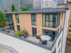 an apartment building with an outdoor patio with an umbrella at City centre apartment with roof terrace. in Birmingham