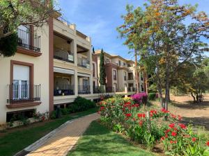 a row of houses with flowers in a park at LA QUINTA ISLA CANELA GOLF by MSHOLIDAYS in Isla Canela