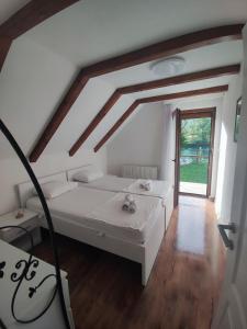 a bedroom with a white bed and a window at Villa Sara on river Una in Bihać