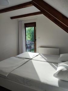 a large white bed in a room with a window at Villa Sara on river Una in Bihać