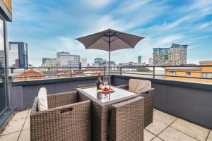 a table on a balcony with an umbrella at City centre apartment with roof terrace. in Birmingham +10 photos