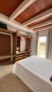 Un dormitorio con una gran cama blanca y una ventana en CAN DAMIA 3 en Cala Saona