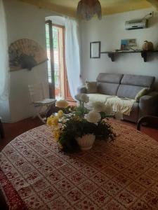 un soggiorno con divano e tavolo con fiori di Casa Belvedere a Manarola