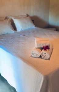 a white bed with two towels on it at Pousada Vila do Alto in Japaratinga