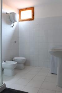 a bathroom with a toilet and a sink at Taverna Porto Conte in Porto Conte