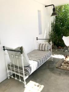 un banco blanco sentado en la esquina de una habitación en VILLA THEIA - SELENE , appartement de charme pour 4 à 6 personnes prés de la plage et du village de Koufonissi, en Koufonisia