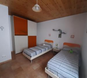 two beds in a bedroom with a wooden ceiling at La casa di Amelia in Borzonasca
