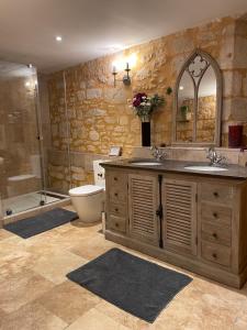 ein Badezimmer mit zwei Waschbecken, einer Dusche und einem WC in der Unterkunft Maison de la Combe in Domme