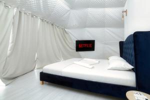 a bedroom with a bed with a netflix sign on it at Seagloo Glamping - Adults Only 12y in Costinesti
