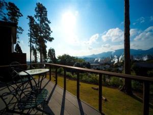 een tafel en stoel op een balkon met uitzicht bij Kannawa Onsen Zekkei no Yado Sakuratei - Vacation STAY 50727v in Beppu