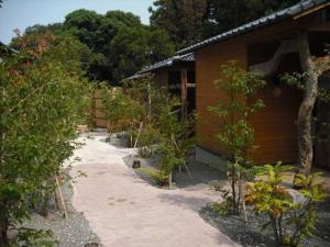 una fila di alberi di fronte a una casa di Kannawa Onsen Zekkei no Yado Sakuratei - Vacation STAY 50724v a Beppu