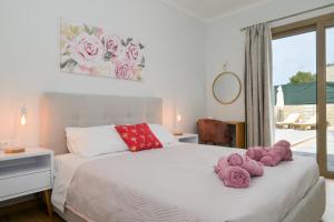 a bedroom with a bed with pink towels on it at Villa Michalis in Liapades