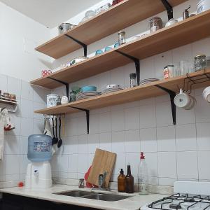eine Küche mit einem Waschbecken und Regalen mit Geschirr in der Unterkunft Mi Hogar tu Hogar in Salta