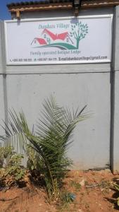 un panneau indiquant un bâtiment devant lequel se trouve une usine dans l'établissement Dunduzu village lodge, à Mzuzu
