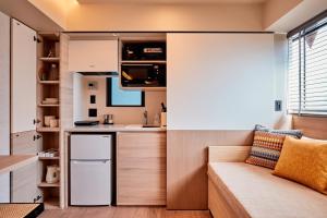 東京にあるLiveGRACE Mabuji Park Hotel - Vacation STAY 51799vの小さなアパートメントで、小さなキッチン(ソファ付)が備わります。