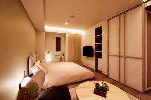 東京にあるLiveGRACE Mabuji Park Hotel - Vacation STAY 51799vのベッドとテーブルが備わるホテルルームです。