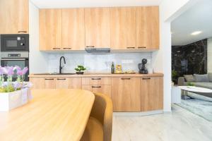 a kitchen with wooden cabinets and a wooden table at Apartmán Discreet in Kysucké Nové Mesto