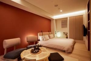 1 dormitorio con 1 cama, mesa y sillas en LiveGRACE Mabuji Park Hotel - Vacation STAY 51965v, en Tokio