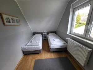 um pequeno quarto com 2 camas e uma janela em Victoria's Village Sauna & Jacuzzi em Kolczewo