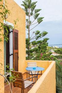 a patio with a table and two chairs on a balcony at Vagia Traditional, Aegina Island in Vaia
