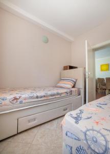 a bedroom with two beds and a refrigerator at Boka bay in Kotor