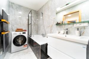 a bathroom with a washing machine and a washer and dryer at Apartmán Discreet in Kysucké Nové Mesto