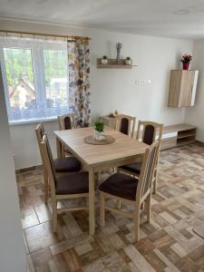 uma sala de jantar com uma mesa de madeira e cadeiras em Chata u Křupalů em Polevsko
