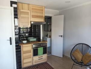 デニアにあるVista al Marの木製のキャビネットとコンロ付きオーブンを備えたキッチン