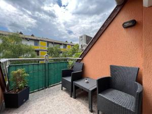 a patio with two chairs and a table on a balcony at Hétvezér Penthouse Apartments in Szeged