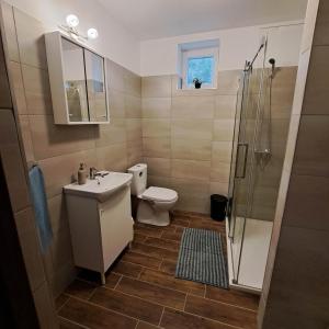 een badkamer met een toilet, een wastafel en een douche bij Öcsi Vendégház in Balatonlelle