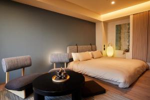 1 dormitorio con 2 camas, mesa y silla en LiveGRACE Mabuji Park Hotel - Vacation STAY 51943v, en Tokio
