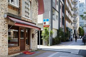 eine Stadtstraße mit Gebäuden und einem Straßenschild in der Unterkunft LiveGRACE Mabuji Park Hotel - Vacation STAY 51943v in Tokio