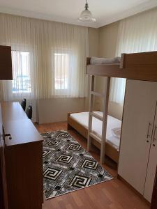 BEŞ YILDIZ APART في طرابزون: غرفة صغيرة مع سرير بطابقين وسجادة