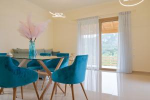 a dining room with a table and blue chairs at Villa Michalis in Liapades