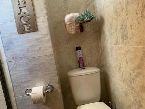 a bathroom with a toilet and a basket of towels at Habitación en apartamento compartido al frente del cc Unico in Barranquilla