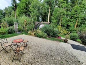 un patio con una mesa y 2 sillas en un jardín en Au Calme Absolu chez Nicolas, en Lindry