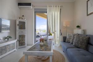 a living room with a blue couch and a table at Christini Cozy Apartment in Souda