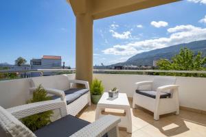 a patio with chairs and a table on a balcony at Christini Cozy Apartment in Souda