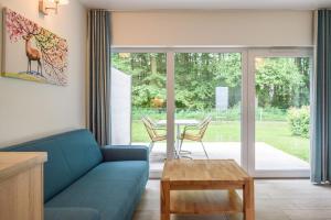 un soggiorno con divano blu e tavolo di Bungis Am Grimnitzsee a Joachimsthal
