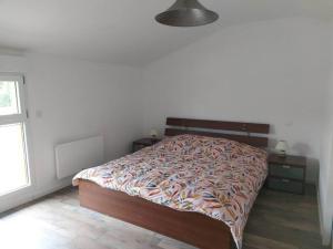 a bedroom with a bed and two tables and a window at LA MAISON D'AUXANNE in Giffaumont-Champaubert +1 photo