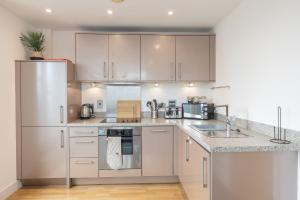 a kitchen with white cabinets and stainless steel appliances at City centre apartment with roof terrace. in Birmingham