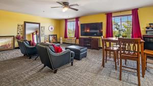 a living room with chairs and a table and a tv at Magnuson Hotel Wildwood Inn Crawfordville in Crawfordville