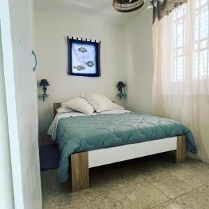 a bedroom with a bed with a green comforter at Seahouse Bocca di Magra in Bocca di Magra