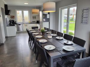 a dining room with a long table and chairs at Villa Bella Zastan Sauna & Jacuzzi in Międzywodzie