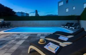 a swimming pool with two couches and a table at Holiday home Split in Split
