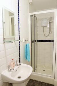 a bathroom with a sink and a shower at Portrush Holiday Hostel Guesthouse in Portrush