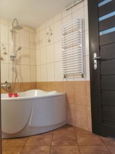 a white bath tub in a bathroom with a window at Zakątek u Natalii in Lubawka