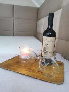 a bottle of wine and a candle on a wooden tray at Zakątek u Natalii in Lubawka