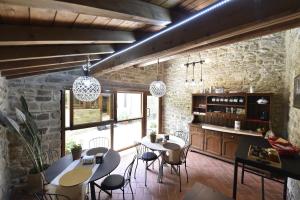 a kitchen with two tables and chairs and a stone wall at B&B A…Monte in Santa Maria
