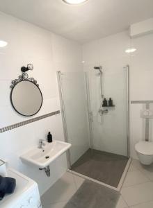 a white bathroom with a shower and a sink at Tijara Apartment in Rijeka